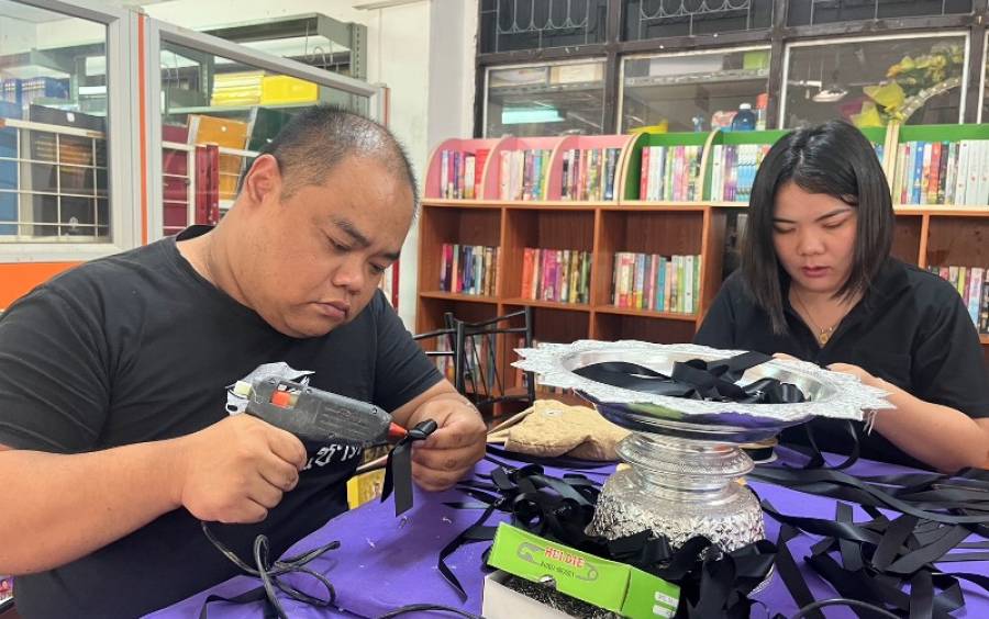 ประดิษฐ์เข็มกลัดโบว์ริบบิ้นจากผ้ากำมะหยี่ สำหรับผู้ร่วมไว้อาลัยและสำนึกในพระมหากรุณาธิคุณแด่สมเด็จพระนางเจ้าสิริกิติ์พระบรมราชินีนาถ พระบรมราชชนนีพันปีหลวง